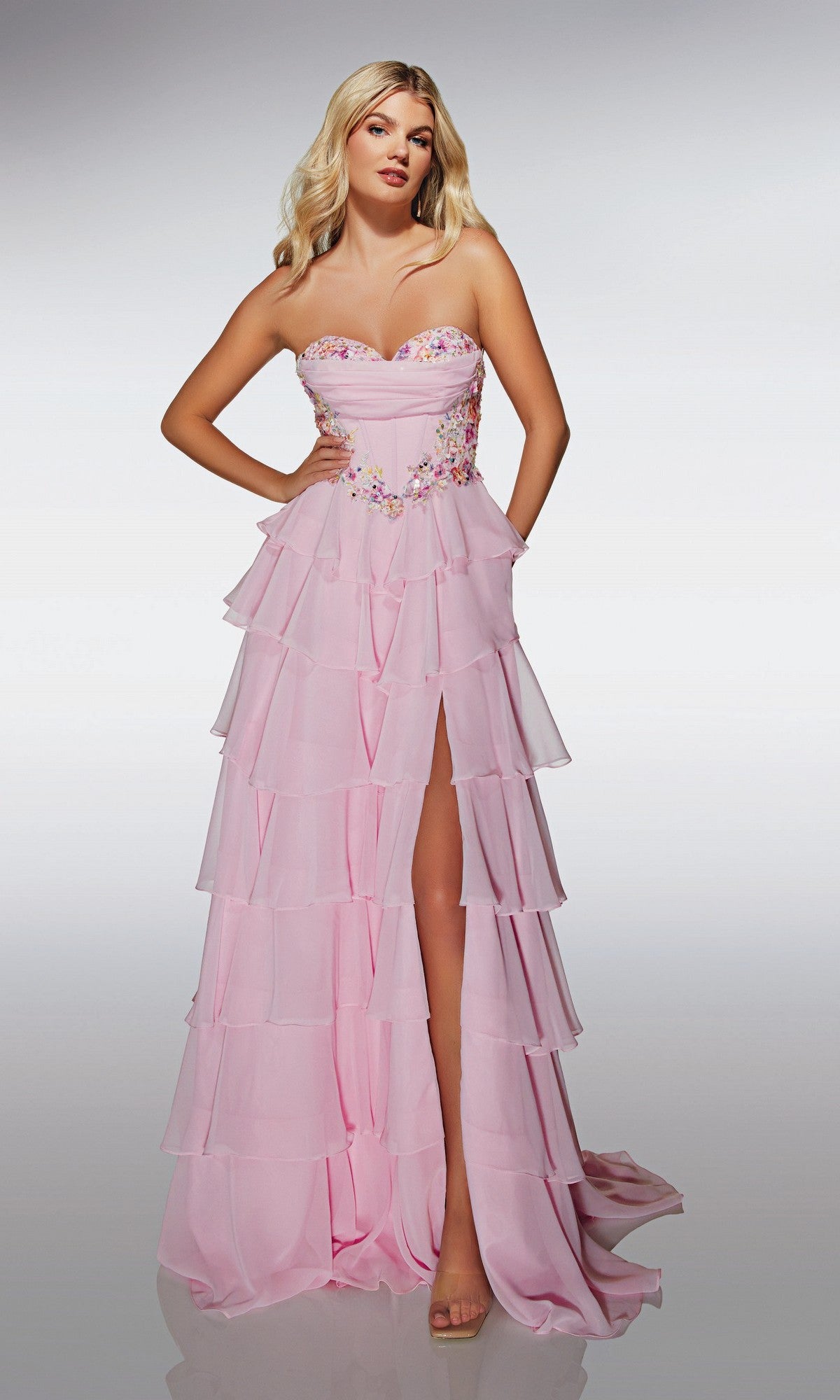 A woman models the Alyce 62013 long prom dress, featuring a strapless chiffon design, sweetheart neckline, corset bodice, floral embellishments, and thigh-high slit against a plain light background.
